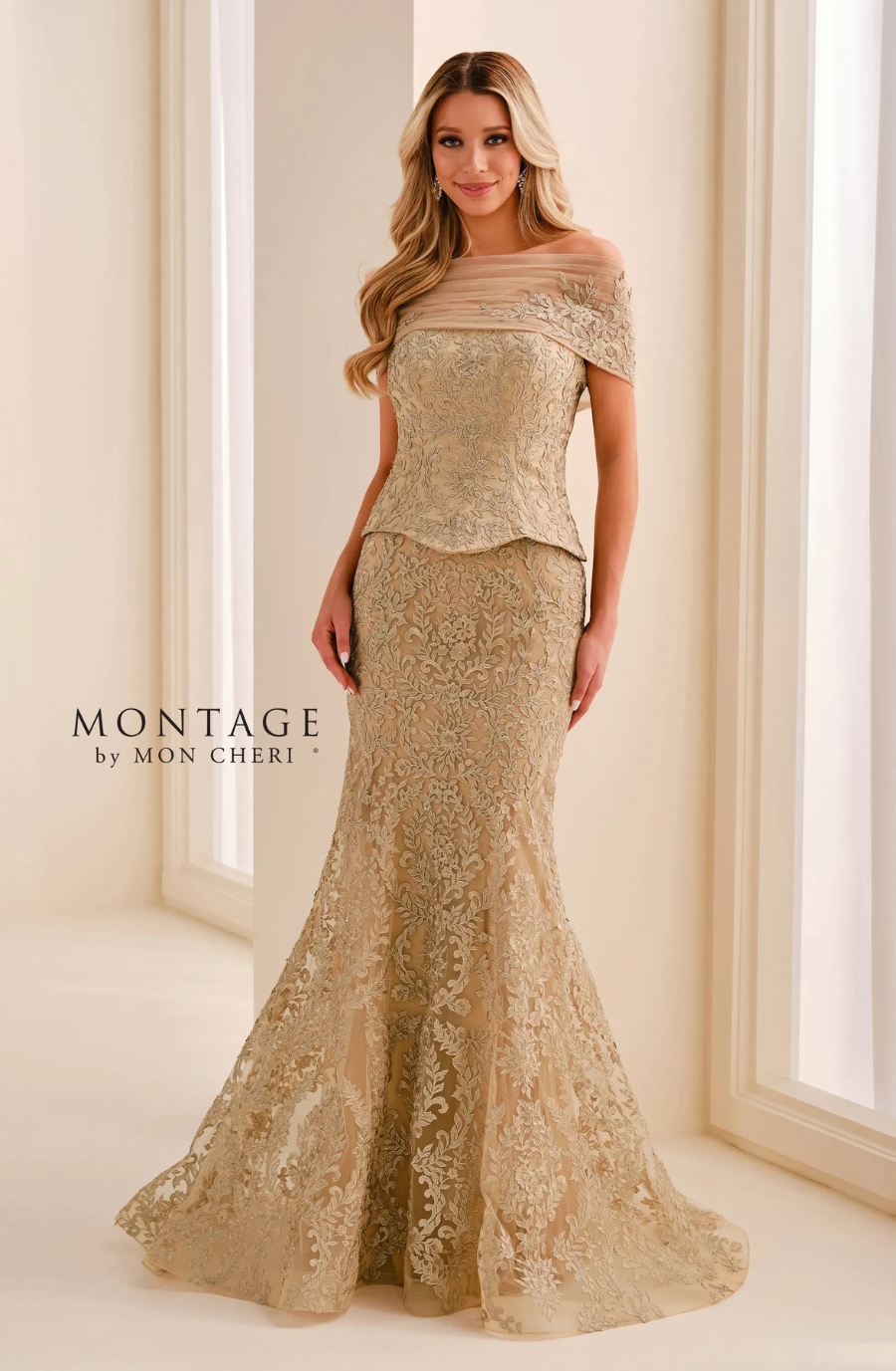 A woman wearing an elegant, gold lace evening gown with an off-the-shoulder neckline, standing in a well-lit interior.
